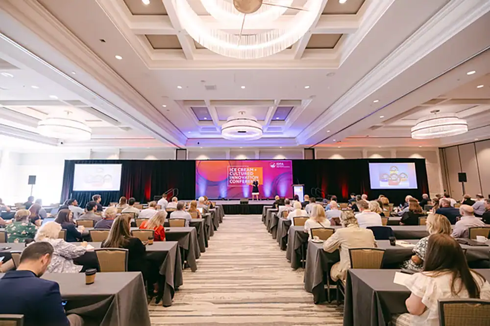 Attendees at a conference learning about effective freezer aisle merchandising and strategies to boost sales and customer engagement.
